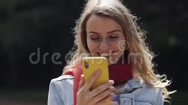 年轻美丽的女人在智能手<strong>机上</strong>使用应用程序的肖像，在手<strong>机上</strong>微笑和发短信。 穿红色衣服的女人