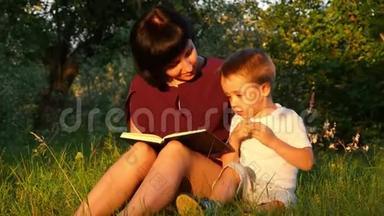一对年轻的母子正<strong>坐在</strong>公园的一棵<strong>树下</strong>晒太阳，读着一本书.. 之间的关系