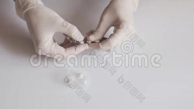一位戴着白色乳胶手套的护士将药片从白色桌子上的<strong>水泡</strong>里挤出来