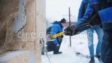 建筑工地。 一个人用锤子敲打一个木箱。 一个钩子从盒子里掉了下来