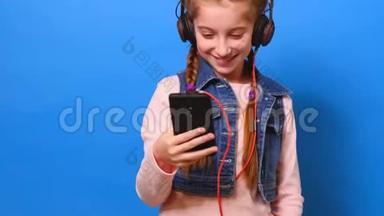 戴着耳机看手机屏幕的小女孩微笑着