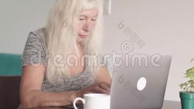 离退休老奶奶在家客厅用笔记本电脑特写镜头。 年老的商人