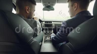 两个男车商和顾客坐在前排座位上谈论汽车模型时的后景