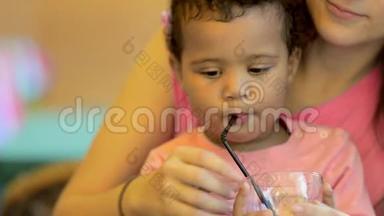 <strong>特写</strong>小女儿在一家咖啡馆<strong>吃饭</strong>，妈妈。 女儿喝柠檬水。