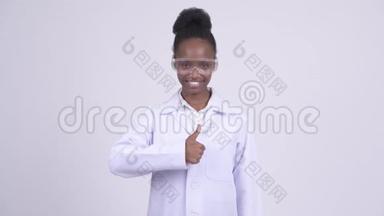 年轻快乐的非洲女医生戴着防护眼镜竖起大拇指