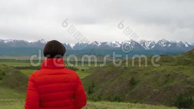 在寒冷的阴天，女徒步旅行者骄傲地站在<strong>山顶</strong>上。 站在<strong>山顶</strong>上的女人。 近距离空中飞行