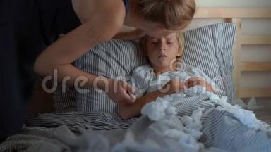 一个生病的小男孩躺在床上。 妈妈测量他的体温。 婴儿流感概念