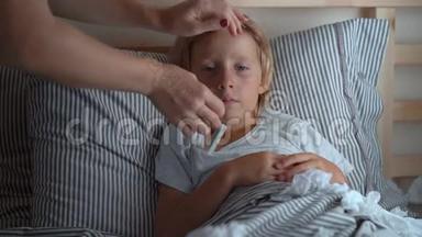 一个生病的小男孩躺在床上。 妈妈<strong>测量</strong>他的<strong>体温</strong>。 婴儿流感概念