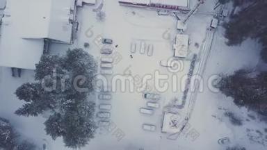 冬季雪盖房屋、停放汽车和绿松树的<strong>高空</strong>俯视。 剪辑。 寒冷的空院