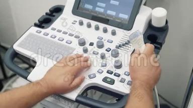 医生的双手特写在超声波扫描仪上。 医务人员使用特种设备..