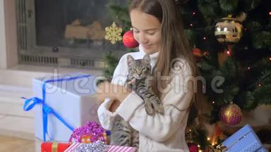 4k视频美丽少女在圣诞树下抚摸可爱的小猫