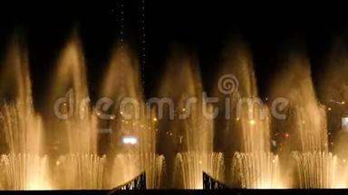 令人惊叹的舞蹈喷泉和水在城市的夜晚飞溅-灯光，颜色和音乐夜展