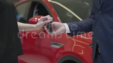 西装革履的未被认出的推销员把车钥匙交给未被认出的女商人，然后在车里握手