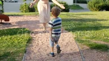 4k视频可爱的笑着蹒跚学步的男孩在公园里向母亲跑和远离母亲