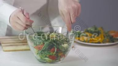 女人用蔬菜和鲁科拉叶做沙拉。 在一碗沙拉的特写镜头中，一个女人与蔬菜相连