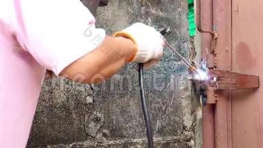 <strong>修理</strong>工人<strong>正在</strong>工厂焊接钢门。 热金属产生的火花。 关闭手工具。