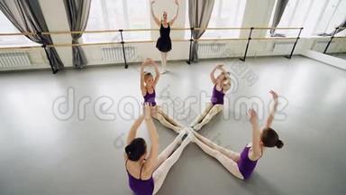 <strong>勤奋</strong>的小芭蕾舞演员练习前弯曲，坐在地板上的工作室伸展和
