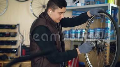 年轻的修理工正在清洗自行车车轮内外的脏布，并用耳机听音乐