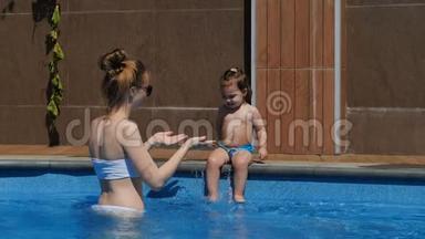 妈妈和小女儿在开放的游泳池里玩耍