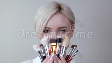 一位留着短发的金发女孩的特写镜头展示了她收集的日常化妆用品必备的画笔。