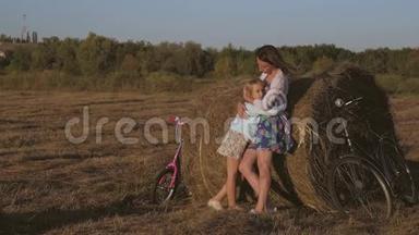 妈妈和<strong>女儿</strong>在干草堆上玩。 快乐的<strong>一家人</strong>在草垛上玩得开心。 家庭观念。