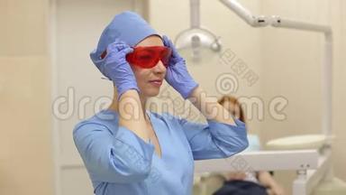 牙医在与病人合作前戴上防护橙色眼镜。