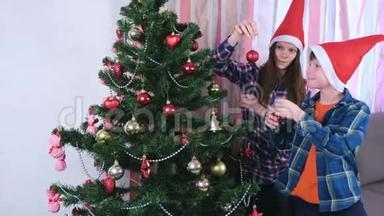 妈妈和儿子戴着<strong>圣诞</strong>帽，用珠子和球装饰<strong>圣诞</strong>树。 家准备<strong>平安夜</strong>..