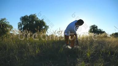 运动男子站在瑜伽姿势在垫子在草地上。 在阳光明媚的夏日里，年轻人在野外训练。 夏季