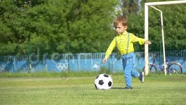 一个孩子在足球场上缓慢地<strong>踢</strong>足球。 总体计划