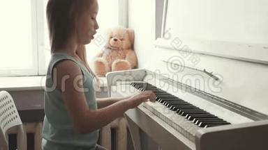 在家学习弹钢琴的小女孩.. 学龄前<strong>儿童</strong>玩音乐<strong>乐器</strong>