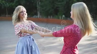 两个漂亮的金发女朋友在公园里玩得很开心。 修女们跳圆舞曲慢动作