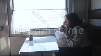 铁路旅行概念。 看着窗外的小<strong>女孩</strong>在车厢里<strong>喝茶</strong>。 穿深色衣服的<strong>女孩</strong>喝酒