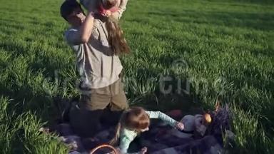 一位年轻的父母和他的成年女儿<strong>在</strong>草地上玩耍，<strong>在</strong>一片垃圾上。 他把<strong>旧</strong>的<strong>扔在</strong>肩上
