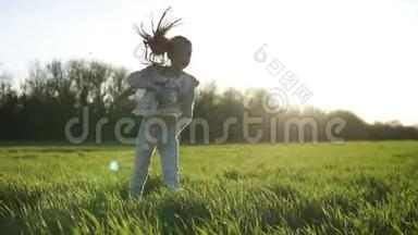 前面看到一个漂亮的年轻女孩在外面的绿色田野上做空翻。 <strong>好好享受</strong>她的时光。 晴天。 微笑