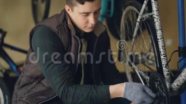 年轻的自行车<strong>修理</strong>工<strong>正在</strong>用特殊的钥匙固定自行车踏板机构。 人专注于他的工作，他是