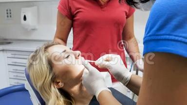 牙科医生在牙齿治疗前从病人口唇上取下口红`特写4k视频