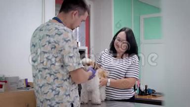 狗主人的女人在一家诊所接受兽医的预约，男医生正在进行<strong>体检</strong>