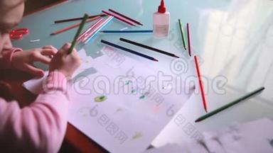 <strong>俯视</strong>镜头左滑动的小白种人女孩在纸上用各种颜色的铅笔在一张<strong>桌子</strong>上。