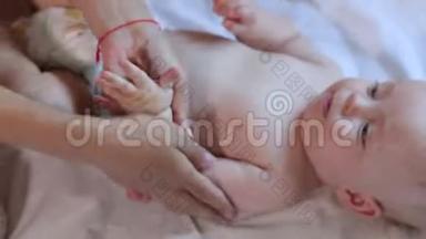 妈妈做新生儿宝宝按摩，在身体上涂油，在白底..