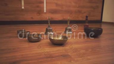 在木地板上有藏语唱碗和铃铛