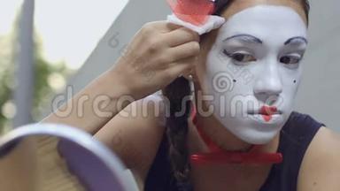 年轻女孩用湿餐巾纸把正确的白色面具戴在脸上