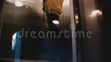 一个年<strong>轻放</strong>松的欧洲女人坐在透明的玻璃墙电梯上，在电话上交谈，微笑。