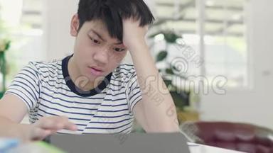 脾气不好的亚洲男孩用平板电脑做作业来查找资料