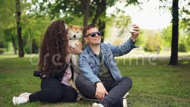 受欢迎的博主正在录制关于他自己的视频，他的妻子和可爱的狗，男人拿着智能手机，说话，看着