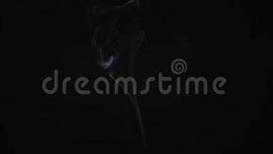 一条薄薄的烟雾从屏幕上升起，在黑色背景上背光拍摄。