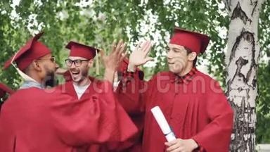 兴奋的年轻男女<strong>毕业</strong>生们正在高举着庆祝<strong>毕业</strong>证书，拥抱和欢笑