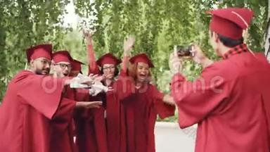 一位拥有智能手机的年轻人正在为毕业生拍照，他们拿着毕业证书，手、手、手指和