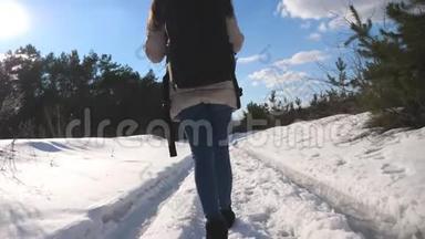 女<strong>游客</strong>在雪地上散步的脚。 冬天背着背包去<strong>森林</strong>小径的女人。 无法辨认的女孩