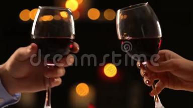 近景男女双手碰杯酒，庆祝节日