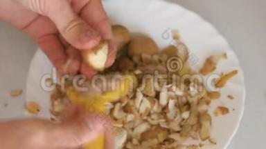 男人`手正在剥土豆，盘子上有黄色的剥皮机。